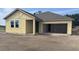 Exterior of home construction shows the structure with a two-car garage and a yard with dirt at 706 Junonia Blvd, New Smyrna Beach, FL 32168