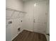 A compact laundry area featuring overhead wire shelving for storage and convenience at 706 Junonia Blvd, New Smyrna Beach, FL 32168
