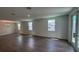 Spacious living room with hardwood floors, modern lighting, and bright, sunlit windows at 706 Junonia Blvd, New Smyrna Beach, FL 32168