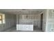 Unfinished kitchen and living room area is ready for customization with drywall, featuring a central island at 706 Junonia Blvd, New Smyrna Beach, FL 32168