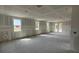 Large unfinished living room with multiple windows and a door leading to the backyard; drywall ready at 706 Junonia Blvd, New Smyrna Beach, FL 32168
