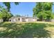 This backyard has a grassy lawn, shade trees, and is surrounded by a wood fence at 7712 Hoosier Pl, Orlando, FL 32807