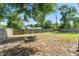 This is a backyard featuring a wooden fence, mature trees, and an area ready for a firepit at 7712 Hoosier Pl, Orlando, FL 32807