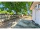 This backyard has mature trees, a concrete pad, and a wood fence at 7712 Hoosier Pl, Orlando, FL 32807