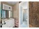 This bathroom has a white sink and white fixtures, with access to the tiled shower in the adjacent bathroom at 7712 Hoosier Pl, Orlando, FL 32807
