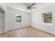Bedroom featuring laminate floors, a ceiling fan, two windows, and plenty of natural light at 7712 Hoosier Pl, Orlando, FL 32807