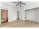 Bedroom featuring a brick accent wall, laminate floors, ceiling fan, and large closet, creating a stylish and functional space at 7712 Hoosier Pl, Orlando, FL 32807