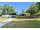Beautiful modern home boasts mature landscaping and charming curb appeal on a sunny day at 7712 Hoosier Pl, Orlando, FL 32807