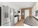 Bright kitchen with stainless steel appliances, white cabinets, laminate floors, and a brick wall accent at 7712 Hoosier Pl, Orlando, FL 32807