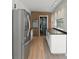 Well-lit kitchen featuring stainless steel appliances, laminate floors and a brick wall accent in the doorway at 7712 Hoosier Pl, Orlando, FL 32807