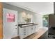 Kitchen featuring sleek white cabinets, black countertops, stainless appliances, and a door to the backyard at 7712 Hoosier Pl, Orlando, FL 32807