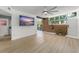 Open-concept living room with a large flatscreen tv, wood flooring, and bright natural lighting at 7712 Hoosier Pl, Orlando, FL 32807