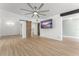 Open-concept living room with a large flatscreen tv, wood flooring, and dark painted accents at 7712 Hoosier Pl, Orlando, FL 32807