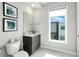 Well-lit bathroom features a modern vanity, toilet, and a window with a view at 7770 Sandy Ridge Dr # 234, Reunion, FL 34747