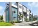 Modern townhouse exterior featuring blue and gray siding with large windows and manicured landscaping at 7770 Sandy Ridge Dr # 234, Reunion, FL 34747