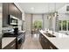 Modern kitchen features stainless steel appliances, dark cabinets and island with seating, and adjacent dining area at 7770 Sandy Ridge Dr # 234, Reunion, FL 34747