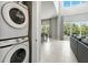A modern living room featuring a washer and dryer nook and a view to the dining area at 7770 Sandy Ridge Dr # 234, Reunion, FL 34747