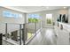 Bright loft featuring sleek railings, expansive windows, and a cozy seating area, filled with natural light at 7770 Sandy Ridge Dr # 234, Reunion, FL 34747