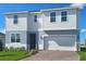 Two-story home with a two-car garage, red brick driveway, and manicured landscaping at 7779 Trapani Loop, Clermont, FL 34714