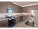 Modern kitchen with stainless steel appliances, granite countertops, and dark wood cabinets at 7779 Trapani Loop, Clermont, FL 34714