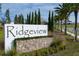 Community sign reading 'Ridgeview' with palm trees and well-manicured landscaping at 7779 Trapani Loop, Clermont, FL 34714