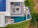 Aerial view of luxury home with modern outdoor lounge, pool, spa, and solar panels on roof at 8157 Elion St, Orlando, FL 32827