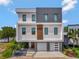 Modern three-story home with a two-car garage, manicured landscaping, and stylish design at 8157 Elion St, Orlando, FL 32827