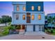 Modern three-story home with a two-car garage, manicured landscaping, and stylish design at 8157 Elion St, Orlando, FL 32827