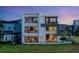 Modern three-story home featuring multiple balconies, outdoor living space, and lots of windows at 8157 Elion St, Orlando, FL 32827