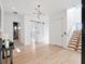 Bright foyer featuring modern lighting, white walls, light hardwood floors, and a floating staircase at 8157 Elion St, Orlando, FL 32827