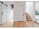 Hallway with hardwood floors, sliding barn door, and modern floating staircase at 8157 Elion St, Orlando, FL 32827