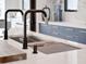 Close-up of kitchen island with modern faucets and sleek design elements at 8157 Elion St, Orlando, FL 32827
