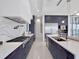 Modern kitchen featuring blue cabinets, stainless steel appliances, and quartz countertops with a waterfall edge at 8157 Elion St, Orlando, FL 32827