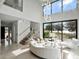 Bright, modern living room featuring a floating staircase, elegant lighting, and large windows with water view at 8157 Elion St, Orlando, FL 32827