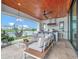 Covered patio with outdoor kitchen, lounge seating, and peaceful lake views at 8157 Elion St, Orlando, FL 32827