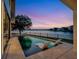 Inviting pool with in-water loungers overlooking a tranquil lake at sunset at 8157 Elion St, Orlando, FL 32827