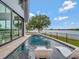 Modern home featuring a luxurious pool with in-water loungers overlooking a serene lake at 8157 Elion St, Orlando, FL 32827