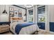Cozy bedroom with light wood floors, blue wainscotting and natural light from multiple windows at 940 Club Cresswind Dr, Lady Lake, FL 32159