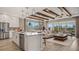 Open-concept living area with a kitchen island, wood beam ceiling, and a comfortable seating area at 940 Club Cresswind Dr, Lady Lake, FL 32159