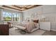 Luxurious main bedroom with a panel accent wall, wood beam ceiling, and backyard views at 940 Club Cresswind Dr, Lady Lake, FL 32159