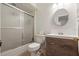 Bathroom with tub shower, round mirror, and wood vanity with white countertop at 978 N Jerico Dr, Casselberry, FL 32707