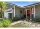 Attractive front entrance with a red door and decorative accents, lush landscaping around the walkway at 978 N Jerico Dr, Casselberry, FL 32707