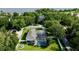 Aerial view of a home featuring a screened pool, well-maintained lawn, and mature trees at 100 Demens St, Oakland, FL 34760