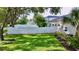 Large backyard with a white fence, lush green grass, and well-maintained landscaping at 100 Demens St, Oakland, FL 34760