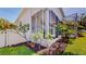 Landscaped backyard area with flowering trees next to an enclosed screened patio at 100 Demens St, Oakland, FL 34760