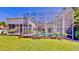 Large screened-in pool area with lush green landscaping and a serene patio setting at 100 Demens St, Oakland, FL 34760