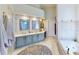 Spacious primary bathroom with double sinks, vanity area, tub, and custom tiling at 100 Demens St, Oakland, FL 34760