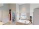Bright bathroom with a corner bathtub and a fireplace with a view of the bedroom at 100 Demens St, Oakland, FL 34760