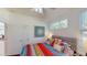 Bedroom featuring a ceiling fan, colorful bedding, and view to the hallway and dining room at 100 Demens St, Oakland, FL 34760