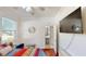 Bedroom featuring a ceiling fan, hardwood floors, television, and view of the bathroom at 100 Demens St, Oakland, FL 34760
